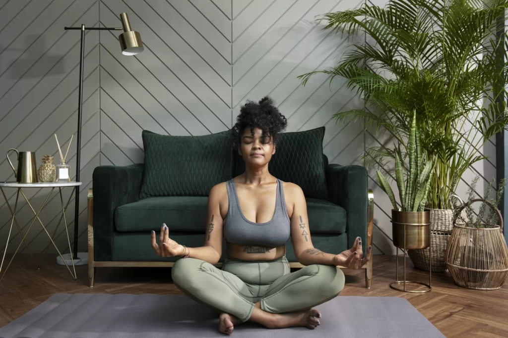 Lady sitting on floor meditating after yoga.  Enhancing mind, body and spirit